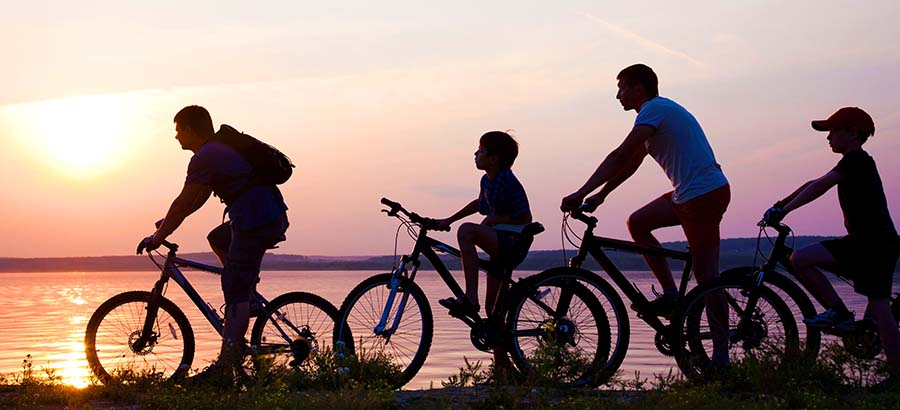 family of four silhouette riding bikes