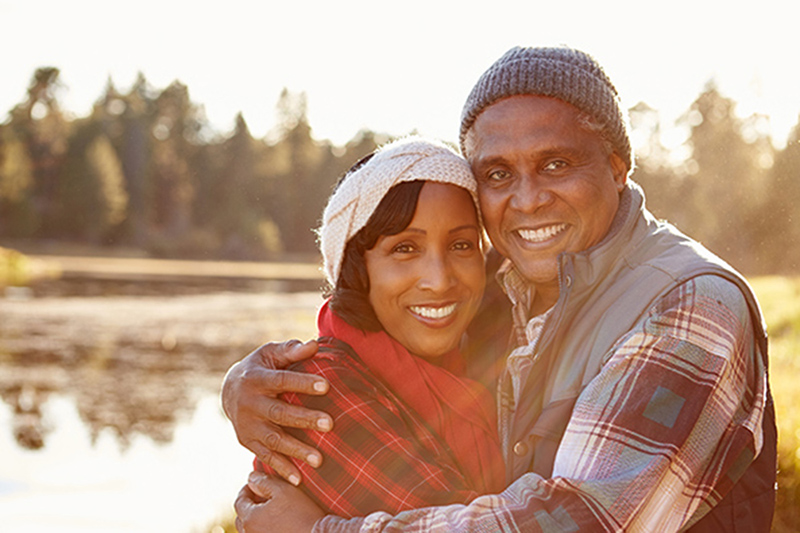 african american couple hugging by pond